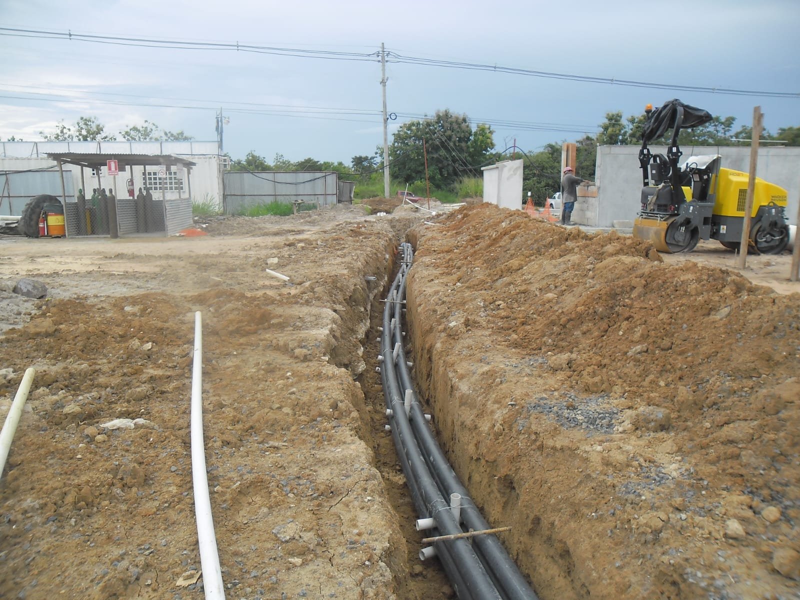 Zanja con tubería eléctrica y compactación con rodillo